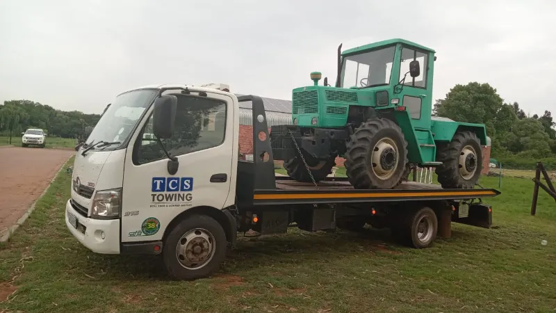 Flatbed truck with green tractor