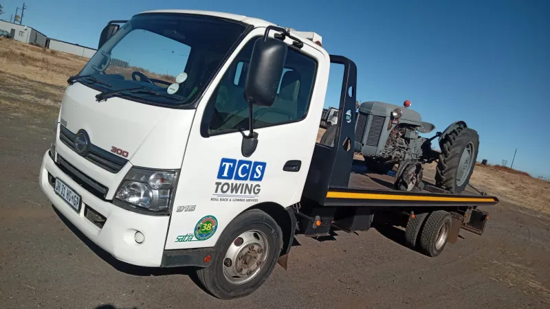 Flatbed truck with vintage tractor