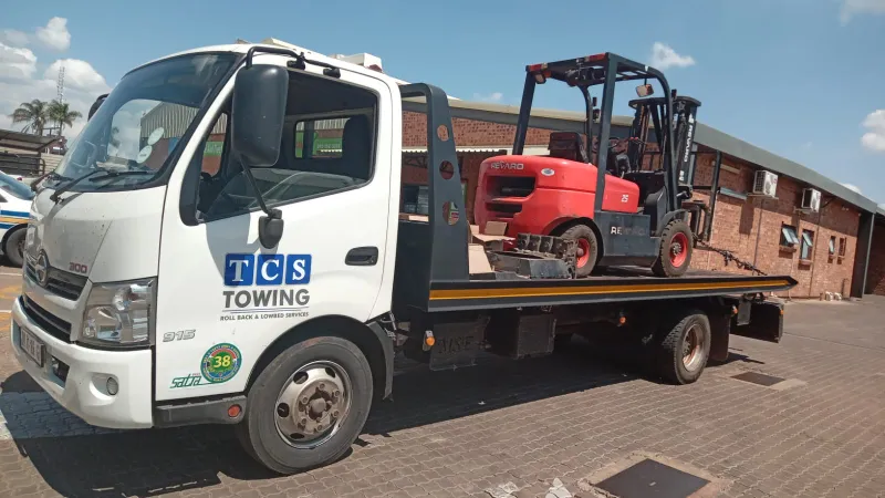 Flatbed truck carrying forklift